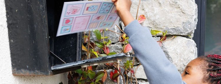 A little girl collecting a postcard from her mailbox