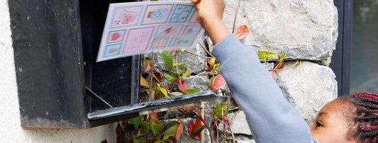 A little girl collecting a postcard from her mailbox