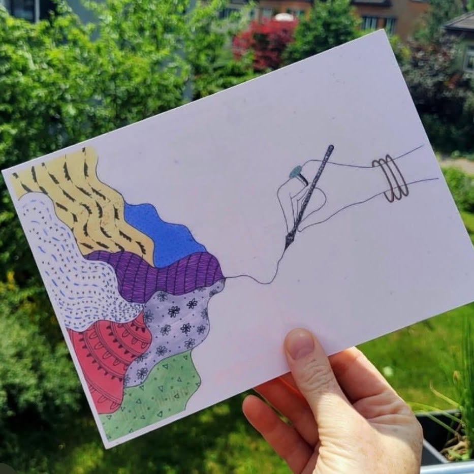 A hand holding Rachel Rothwell's Draw Me A Line postcard