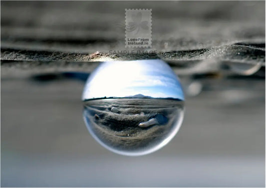 This photographic postcard depicts Muckish through a lens ball from the Boardwalk in Carrigart, County Donegal.